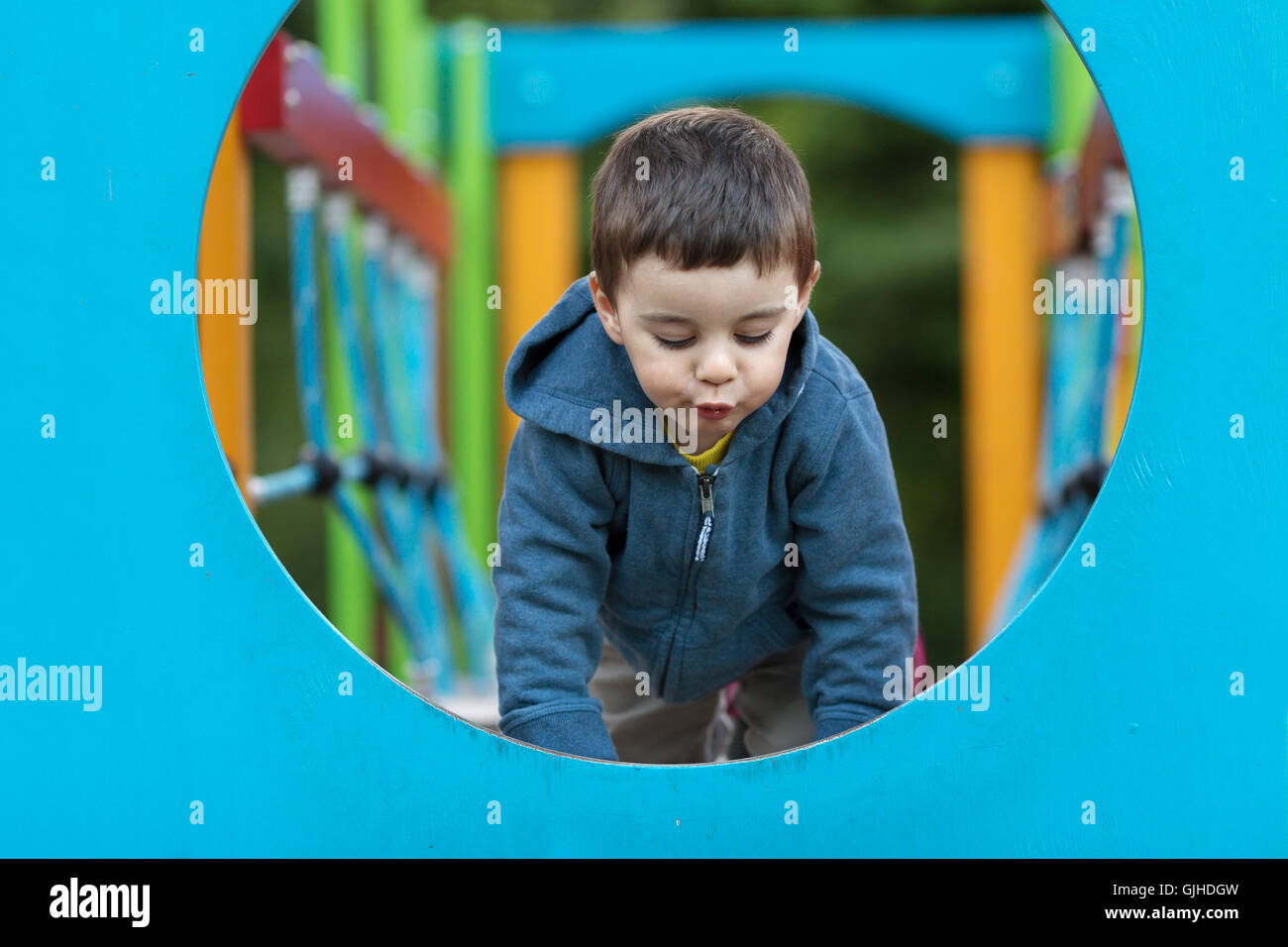 Boy on climbing play equipment in playground Stock Photo