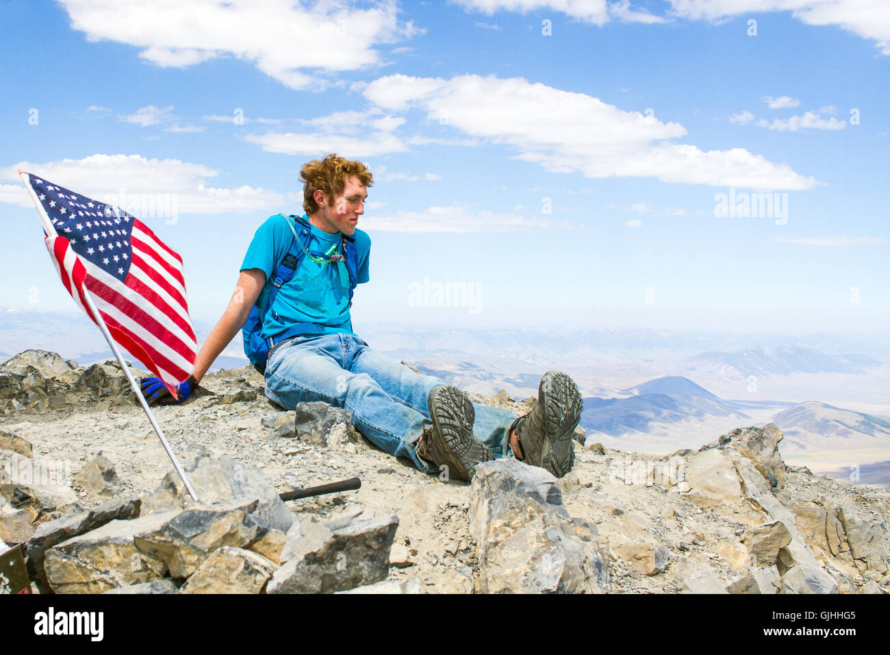 Teenage boy sitting on mountain summit, Borah Peak, Idaho, America, USA Stock Photo