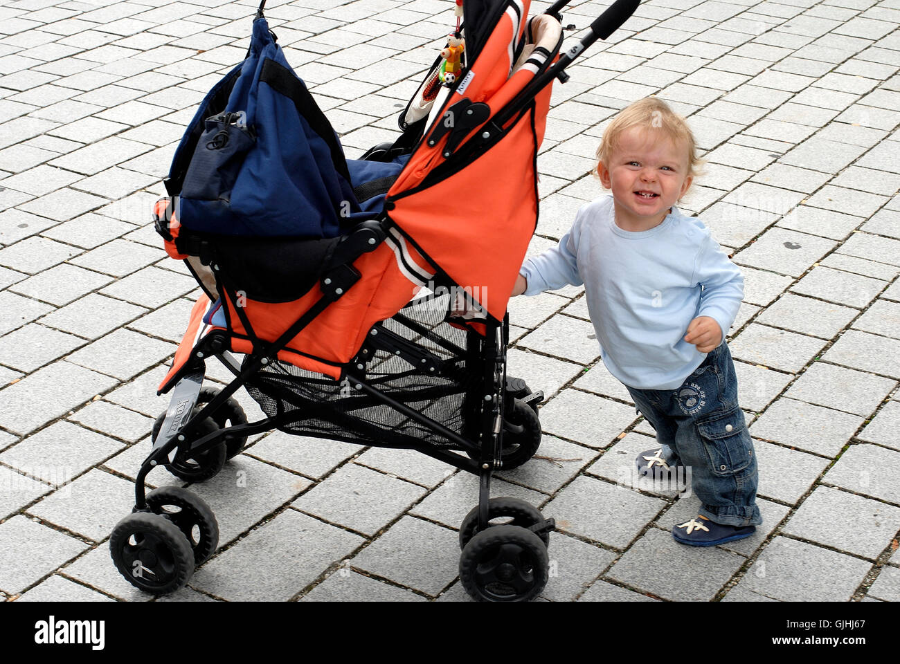 child pushes stroller Stock Photo