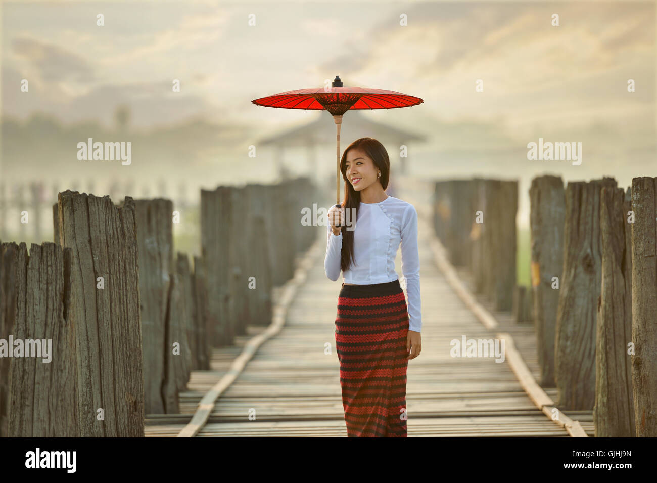 Woman standing on U Bein Bridge, Mandalay, Myanmar Stock Photo