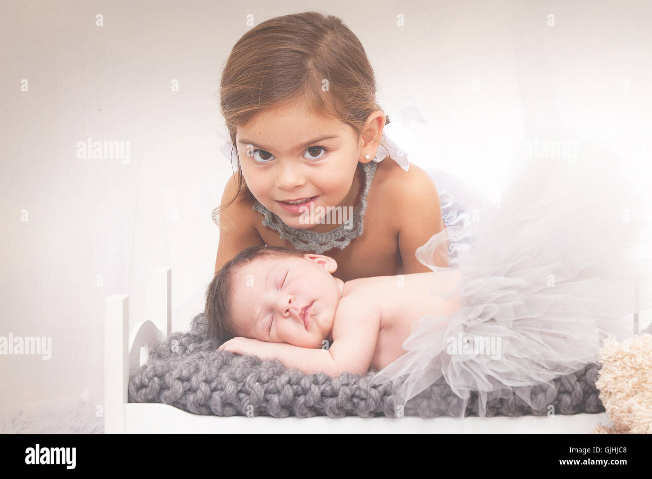 Portrait of a girl with newborn baby sister Stock Photo