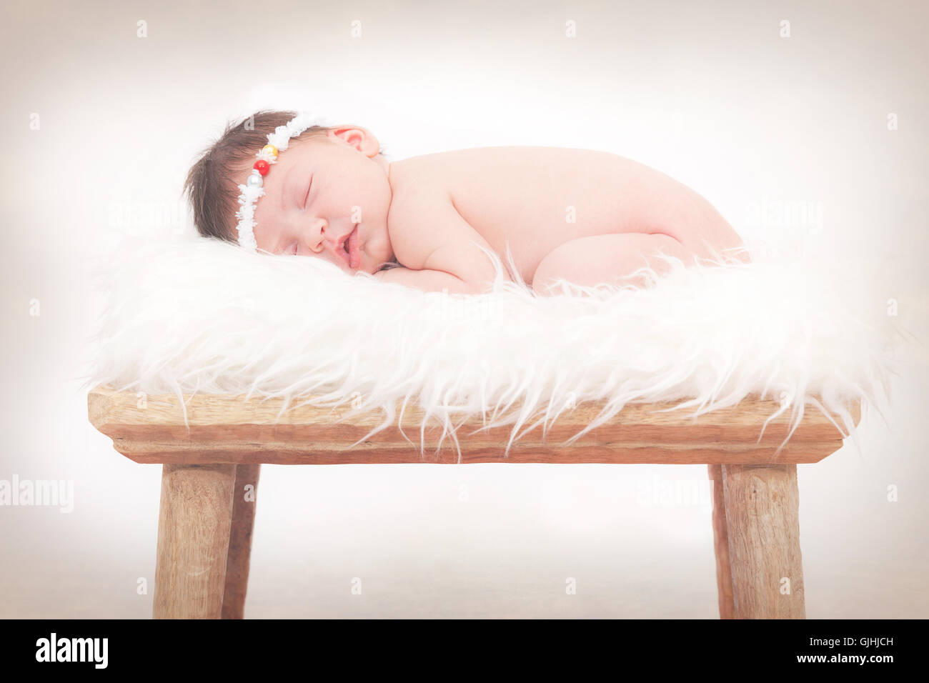 Portrait of a newborn baby girl sleeping on fluffy rug Stock Photo