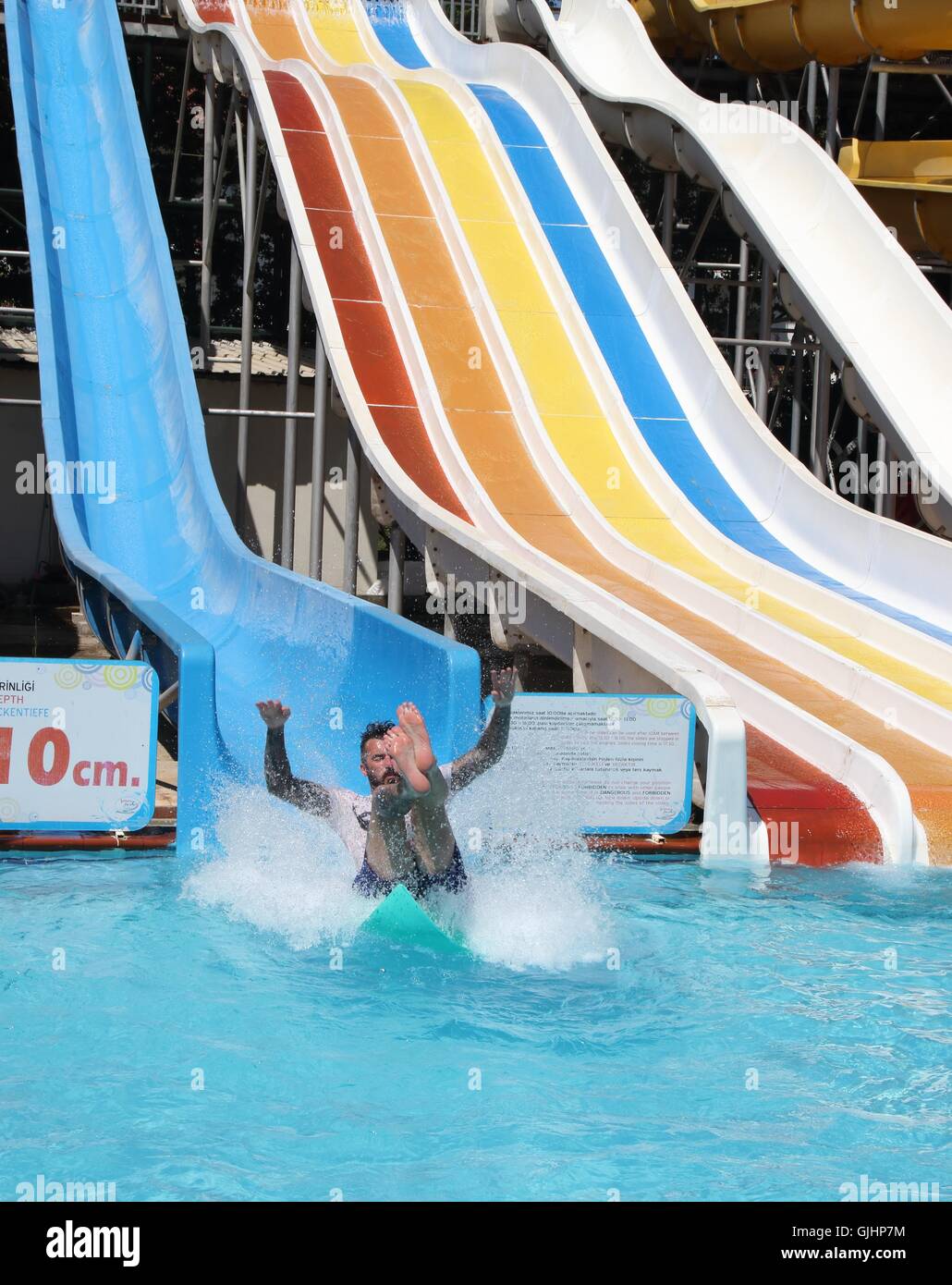 An englishman having fun on a water slide in a waterpark while on