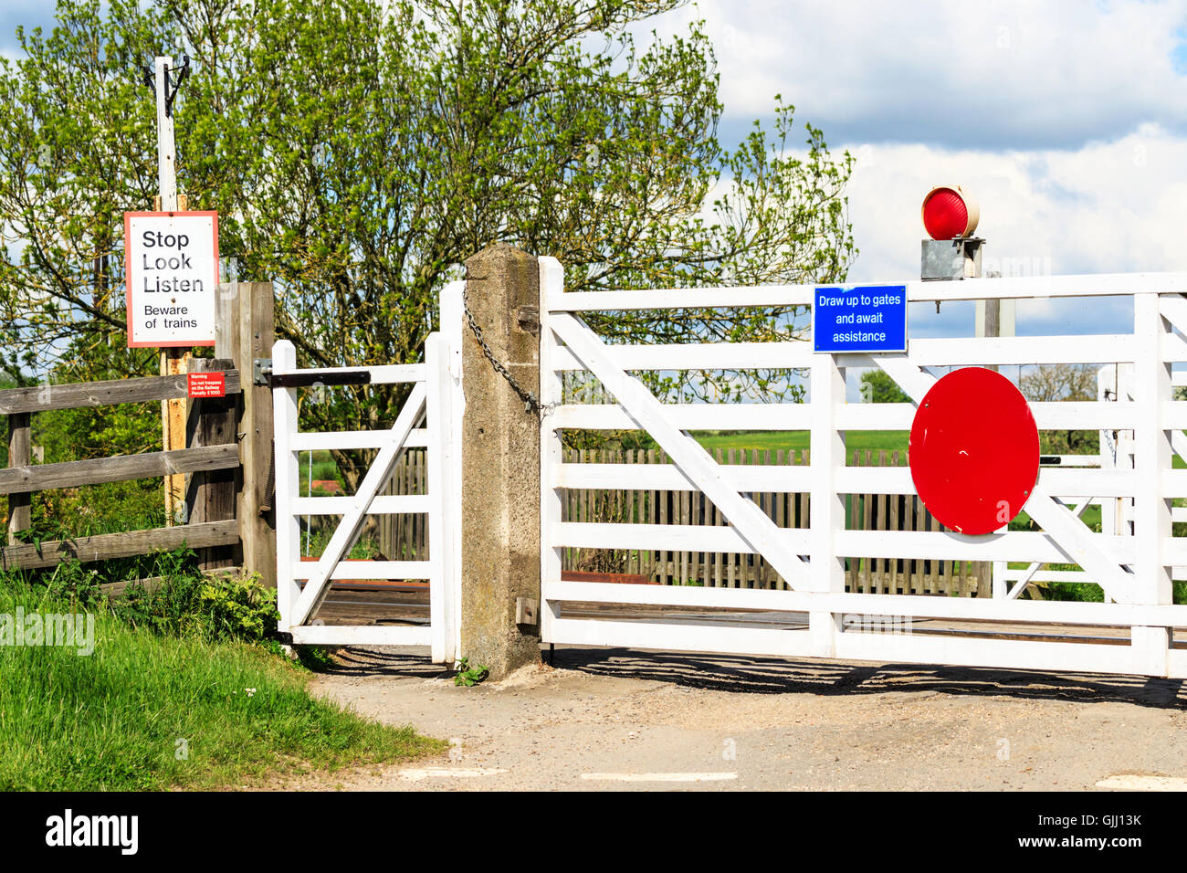 Old British wooden level crossing gates and warning signs. UK Stock Photo