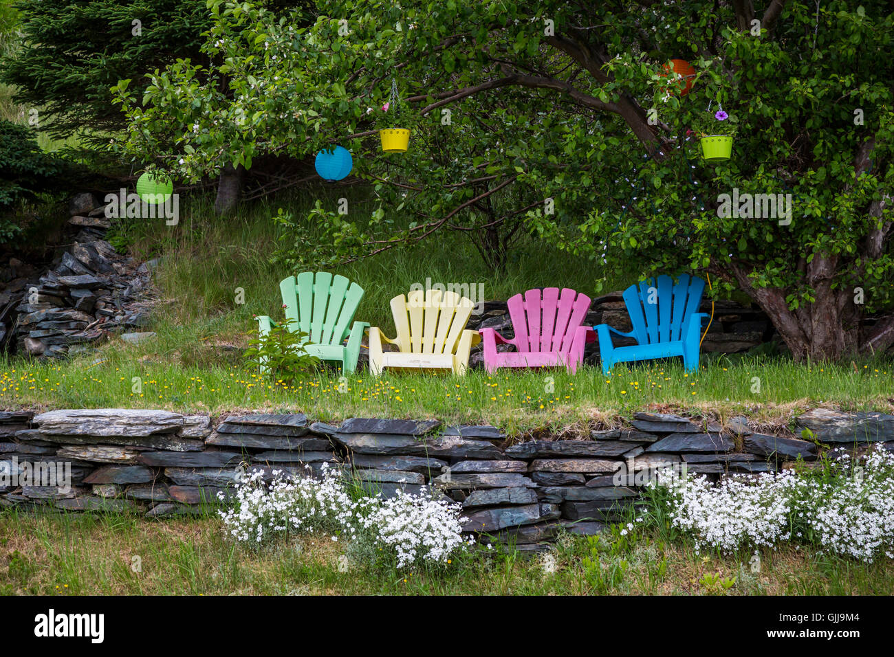 A garden with colorful Adirondack chairs near Bay Roberts, Newfoundland and Labrador, Canada. Stock Photo