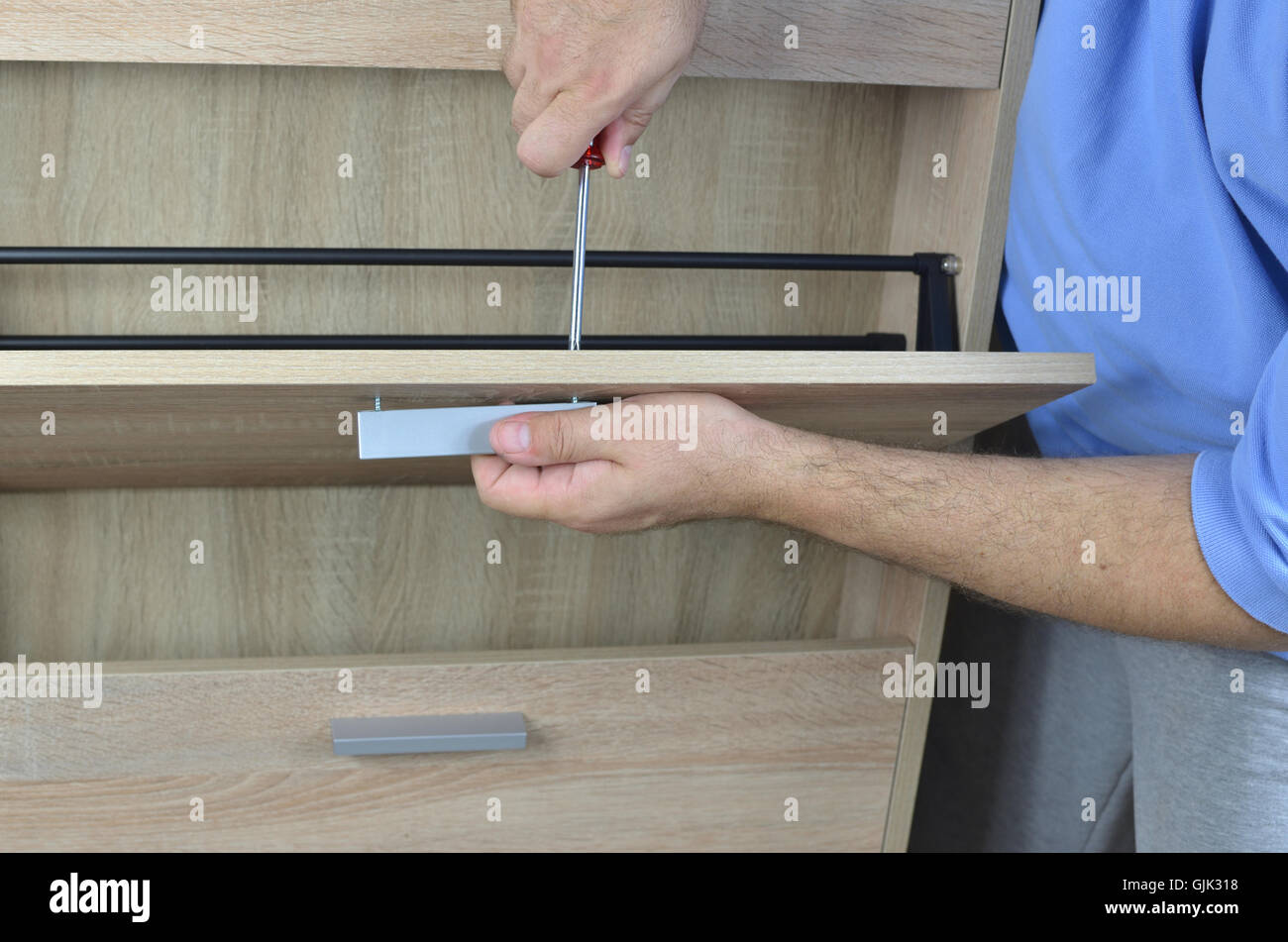Fixing a pull on a drawer of a shoe with a screwdriver Stock