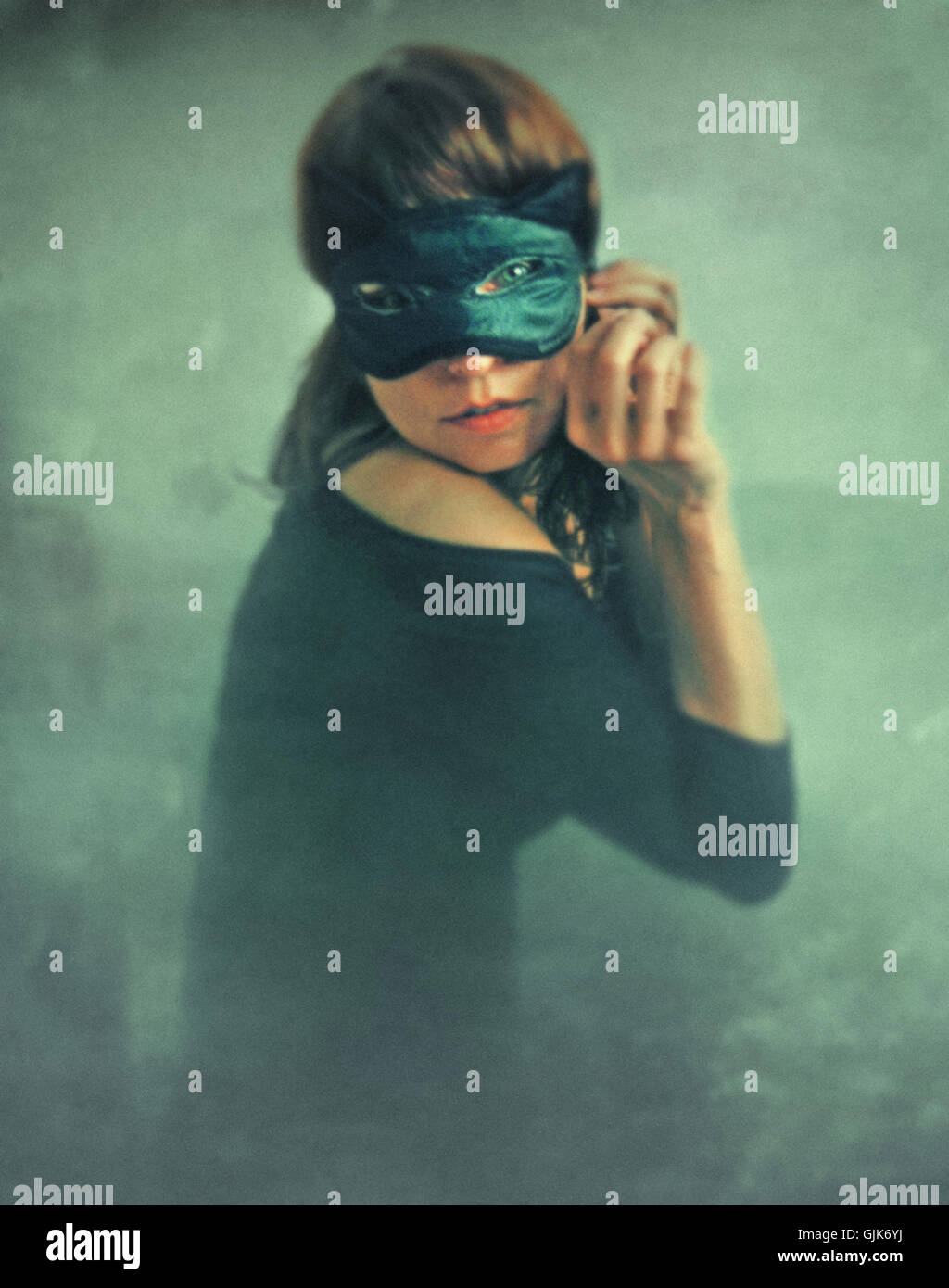 mysterious young woman wearing black cat mask on her face Stock Photo