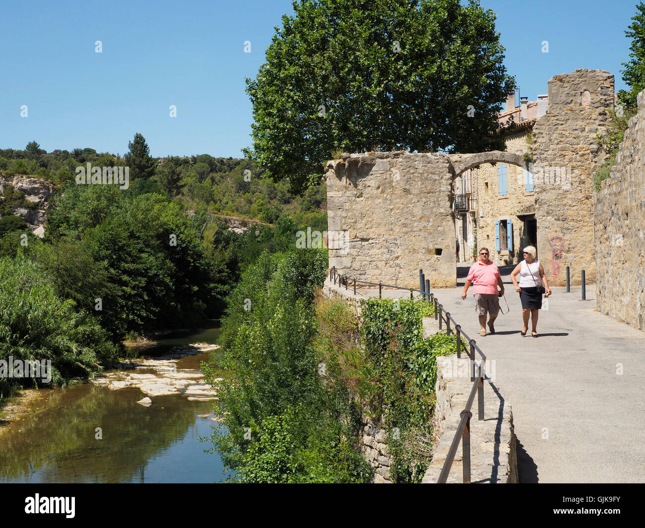 Tourists exploring the historic medieval town of Lagrasse, southern France, known for it's magnificent abbey. Stock Photo