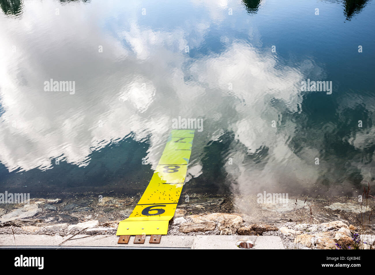 Yellow sign with numbers for measuring water level in a lake Stock Photo