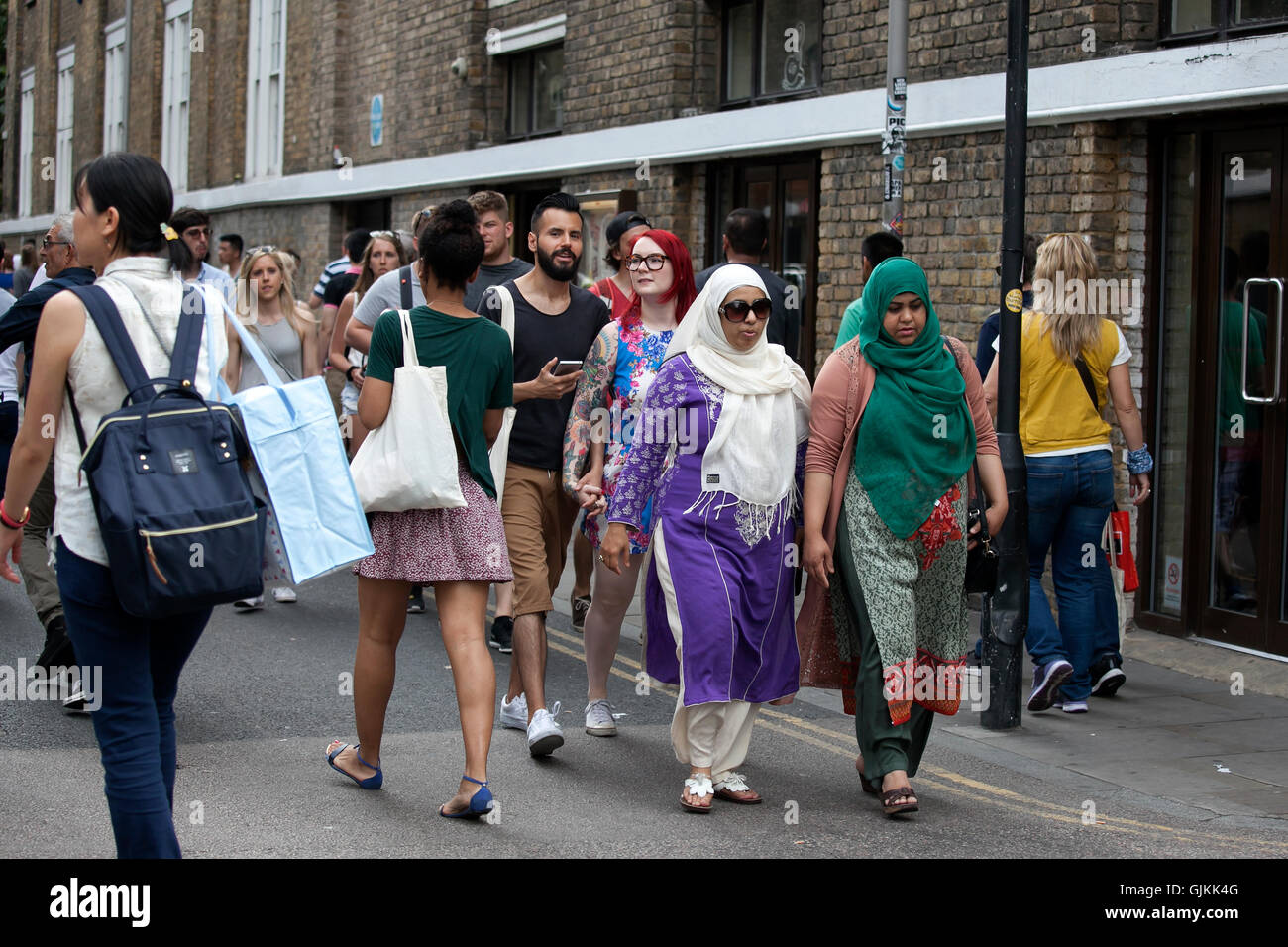 multinational crowd wanders through Brick Lane in London Stock Photo