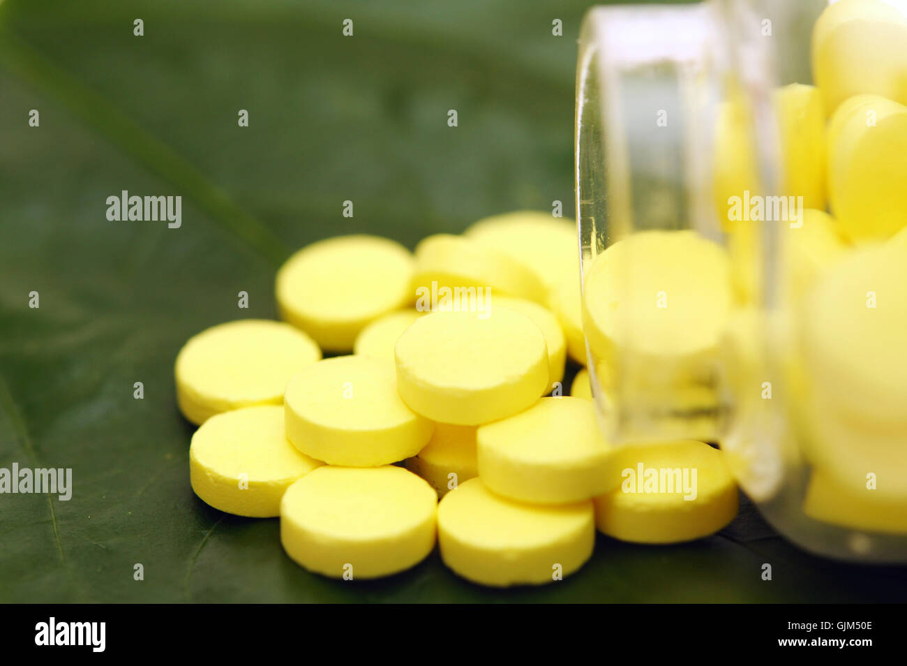 yellow pill over a green leaf Stock Photo Alamy