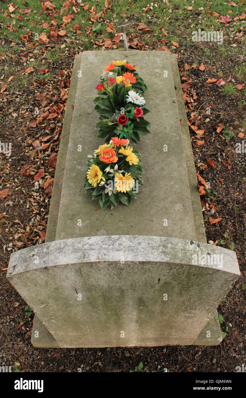 Tombstone covered with flowers Stock Photo Alamy