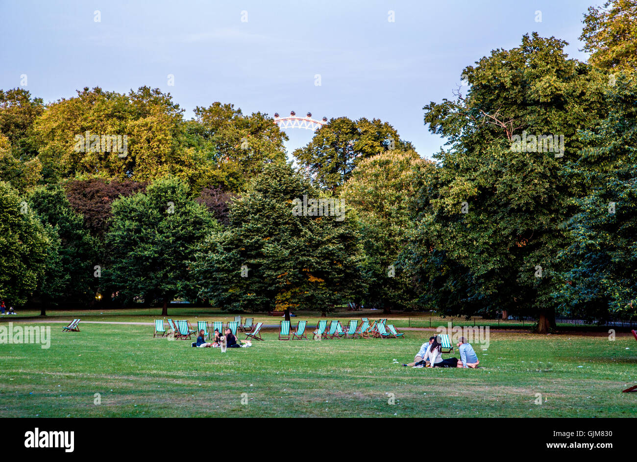 Tourists Sitting in St. James Park at Dusk London UK Stock Photo