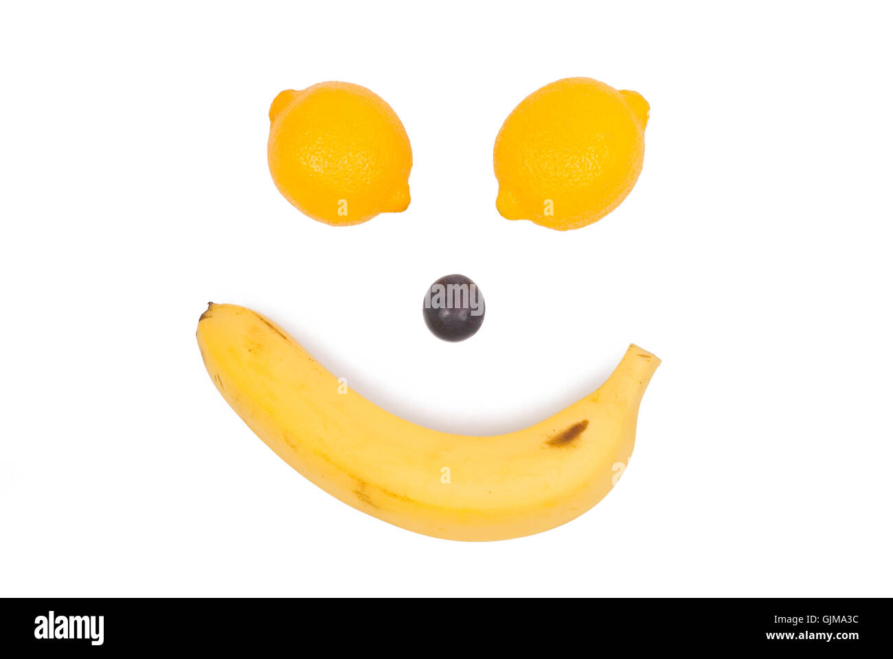 Fruit like man's face. Lemon, banana and grape Stock Photo