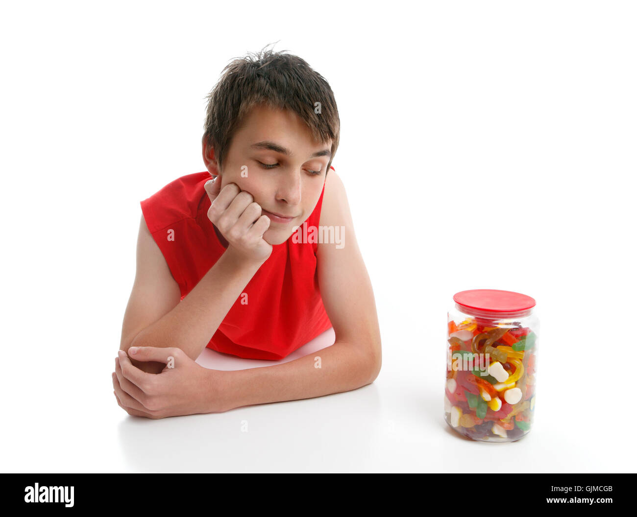 Boy ponders to open jar confectionery Stock Photo