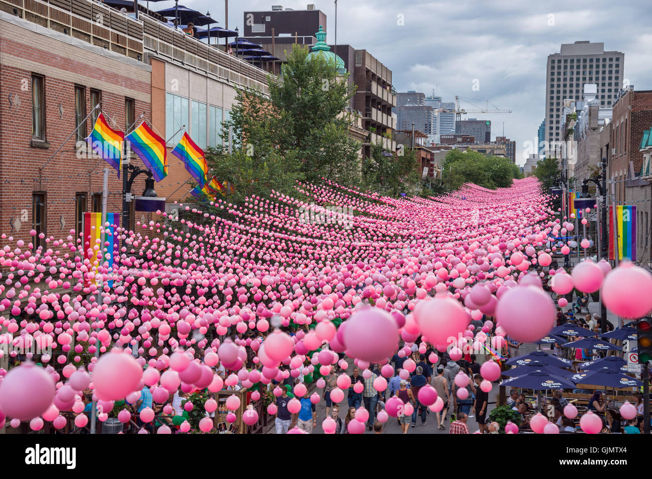 Montreal, CA - 14 August 2016: Pink balls across Rue Sainte Catherine in the Gay Village of Montreal with gay rainbow flags Stock Photo