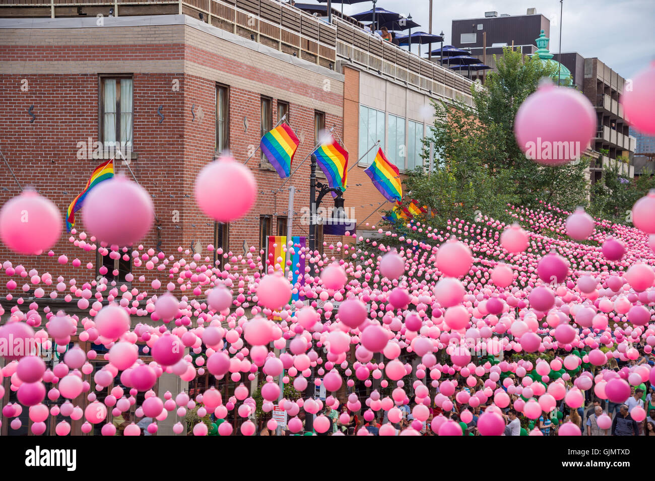 Montreal, CA - 14 August 2016: Pink balls across Rue Sainte Catherine in the Gay Village of Montreal with gay rainbow flags Stock Photo