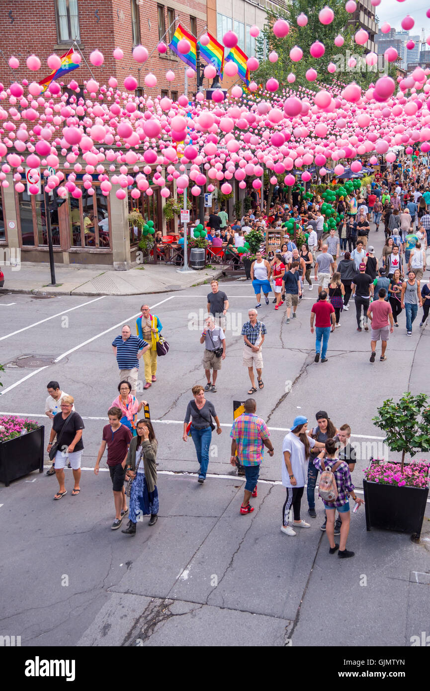Montreal, CA - 14 August 2016: Pink balls across Rue Sainte Catherine in the Gay Village of Montreal with gay rainbow flags and Stock Photo