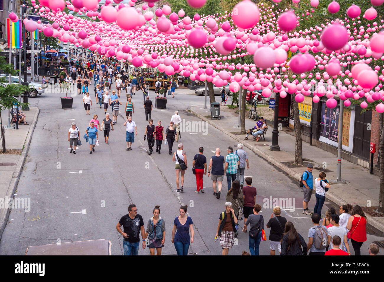 Montreal, CA - 14 August 2016: Pink balls across Rue Sainte Catherine in the Gay Village of Montreal with gay rainbow flags and Stock Photo