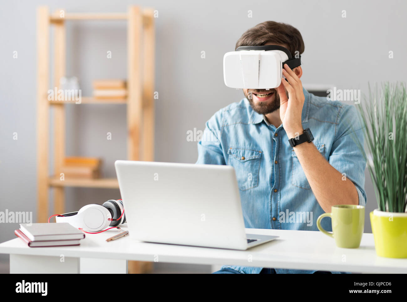 Man Using The Virtual Reality Cheerful man using virtual reality device Stock Photo - Alamy