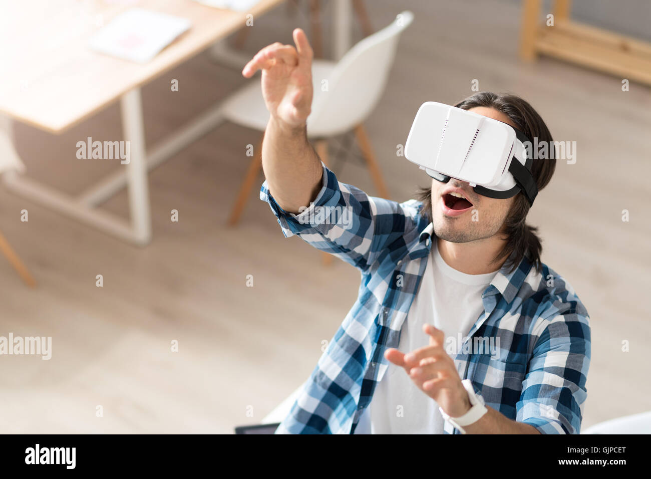 Man Using The Virtual Reality Positive man using virtual reality device Stock Photo - Alamy