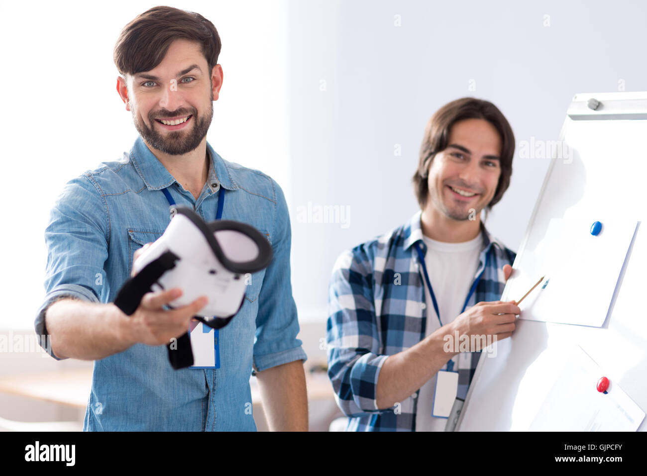 Positive man holding virtual reality glasses Stock Photo - Alamy