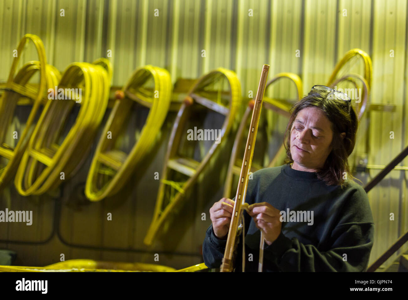 Shingleton, Michigan - Julie Holmes strings snowshoes at the Iverson  Snowshoe factory Stock Photo - Alamy