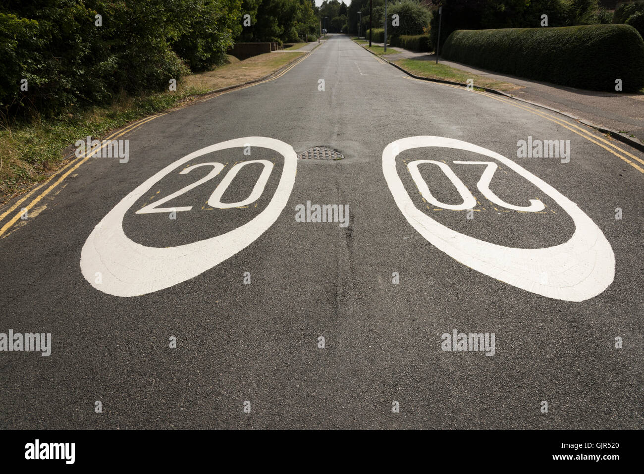 Close up wide angle view of 20 miles per hour mph speed limit signs painted on a road in Cambrudge UK Stock Photo