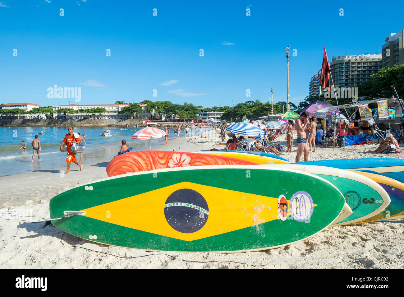 RIO DE JANEIRO - APRIL 5, 2016: Brazil flag stand up paddle surfboard waits for customers on Copacabana Beach. Stock Photo