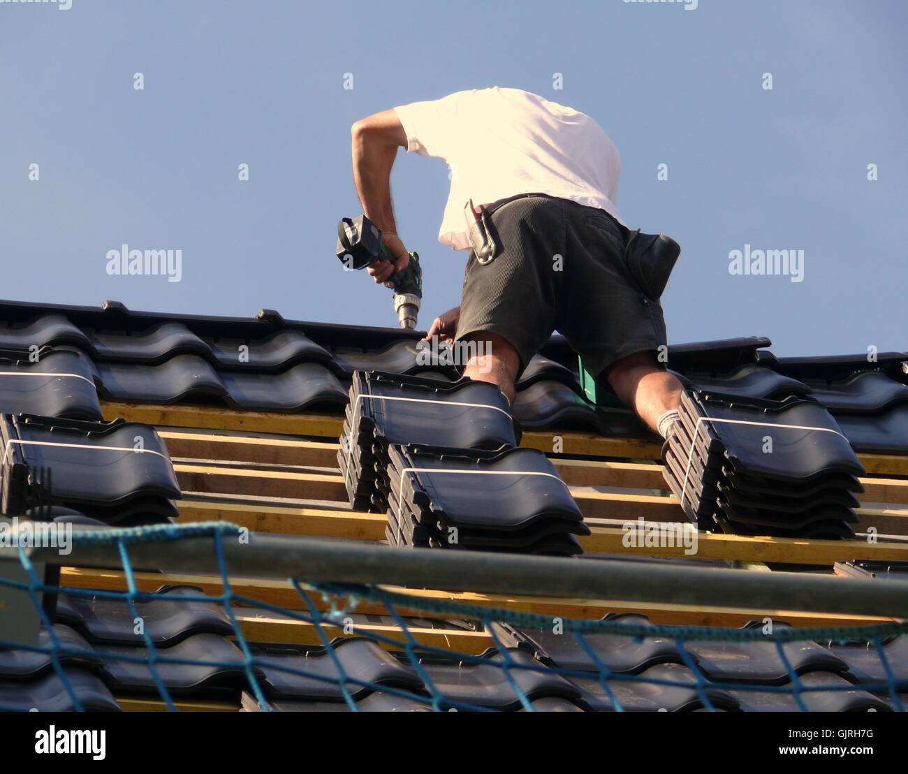 Roofer Doing Ridges work on the roof ridge Stock Photo - Alamy