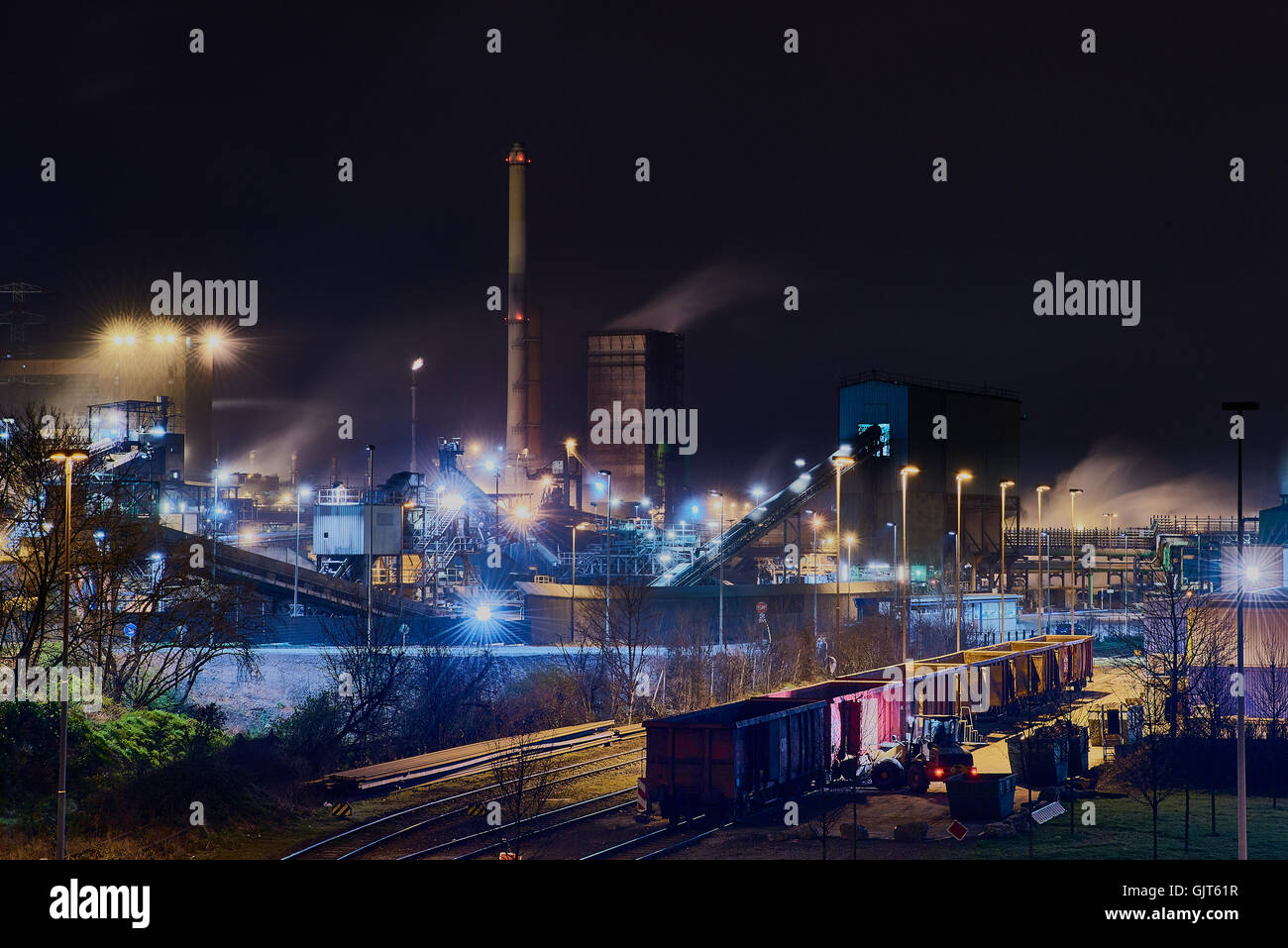 Steelplant in Duisburg, Germany, at night with a train in the front of the scene - very surreal Stock Photo