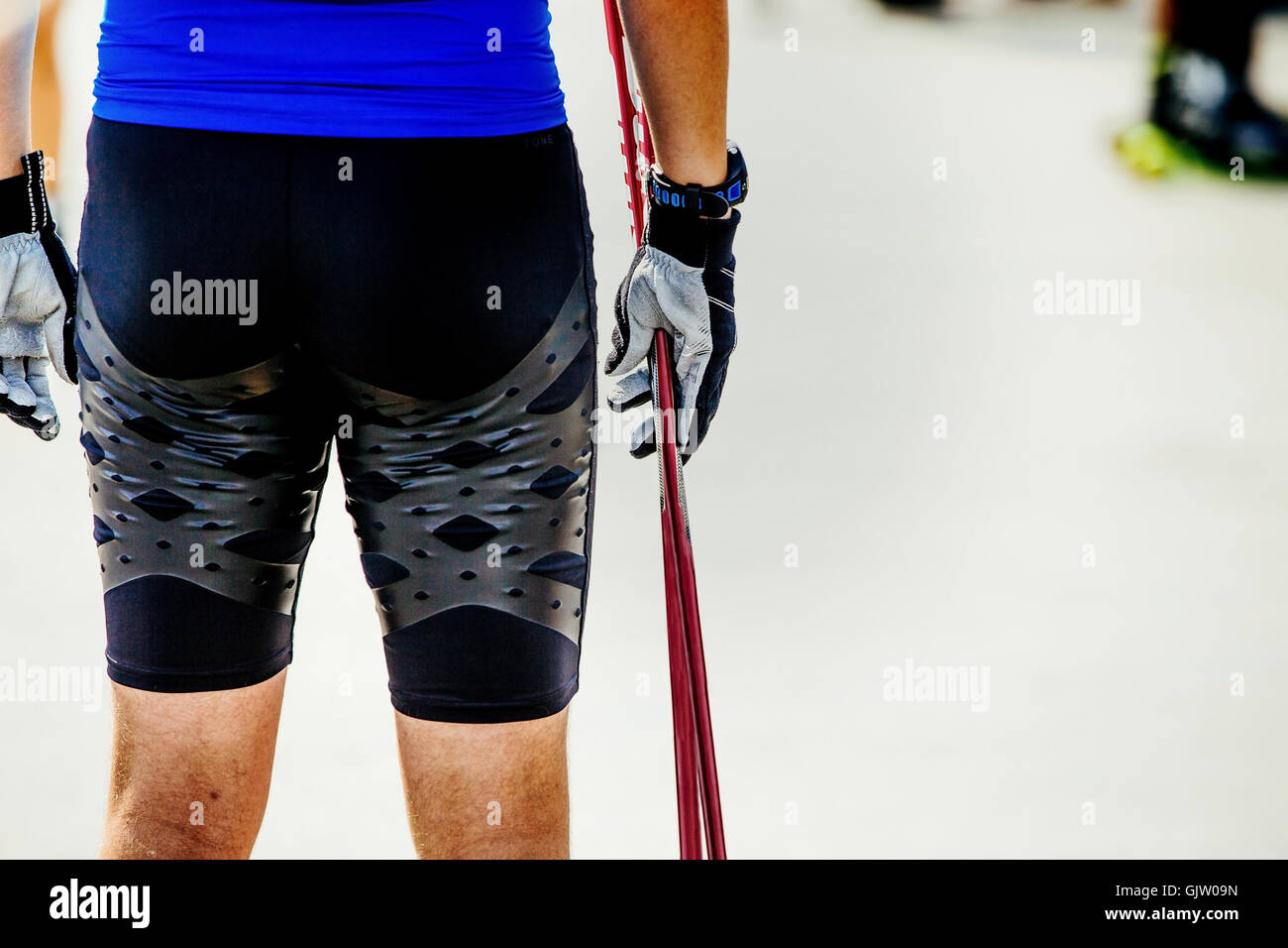 closeup male athlete of ski-roller holds ski poles Stock Photo