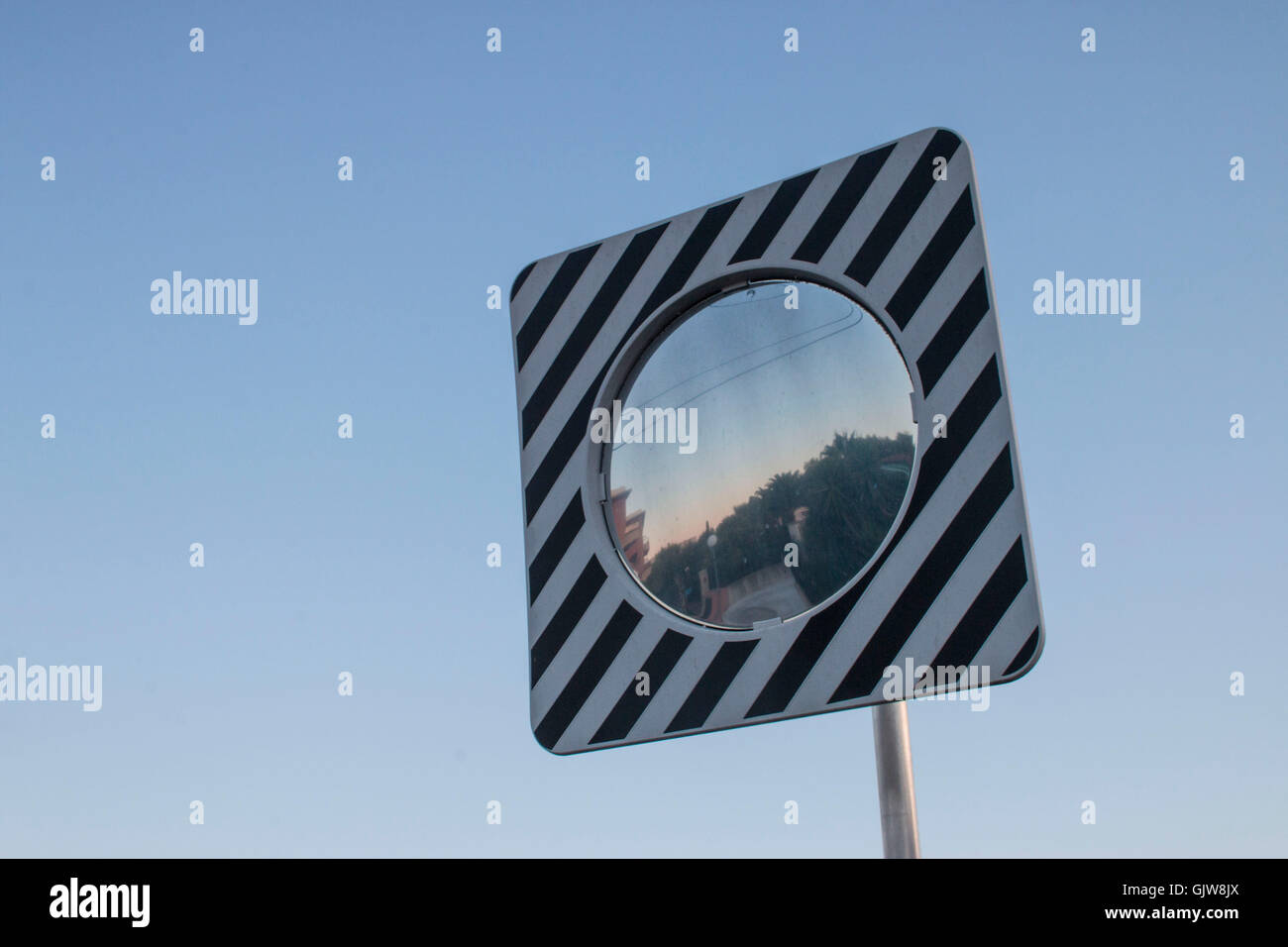 Roadside convex mirror against blue sky Stock Photo - Alamy
