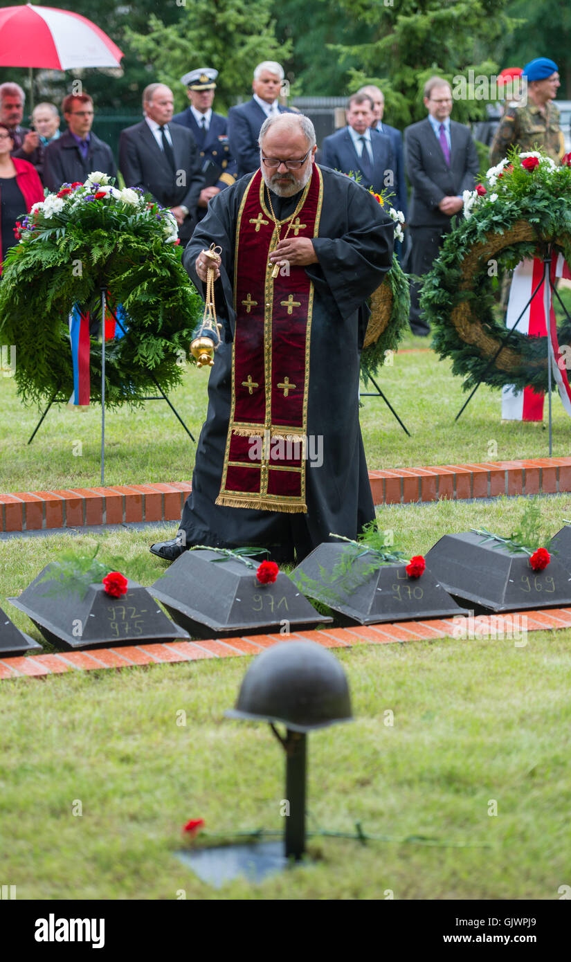 Lebus, Germany. 18th Aug, 2016. A clergyman takes part in the burial of the remains of Soviet soldiers from the second world war, during their burial at the military cemetary in Lebus, Germany, 18 August 2016. The 35 red army soldiers died in the heavy fighting in the Oderbruch area in early 1945. The mortal remains were recovered by the German War Graves Commission last year, and can now finally be laid to rest, more than 70 years after the war's end. PHOTO: PATRICK PLEUL/DPA/Alamy Live News Stock Photo