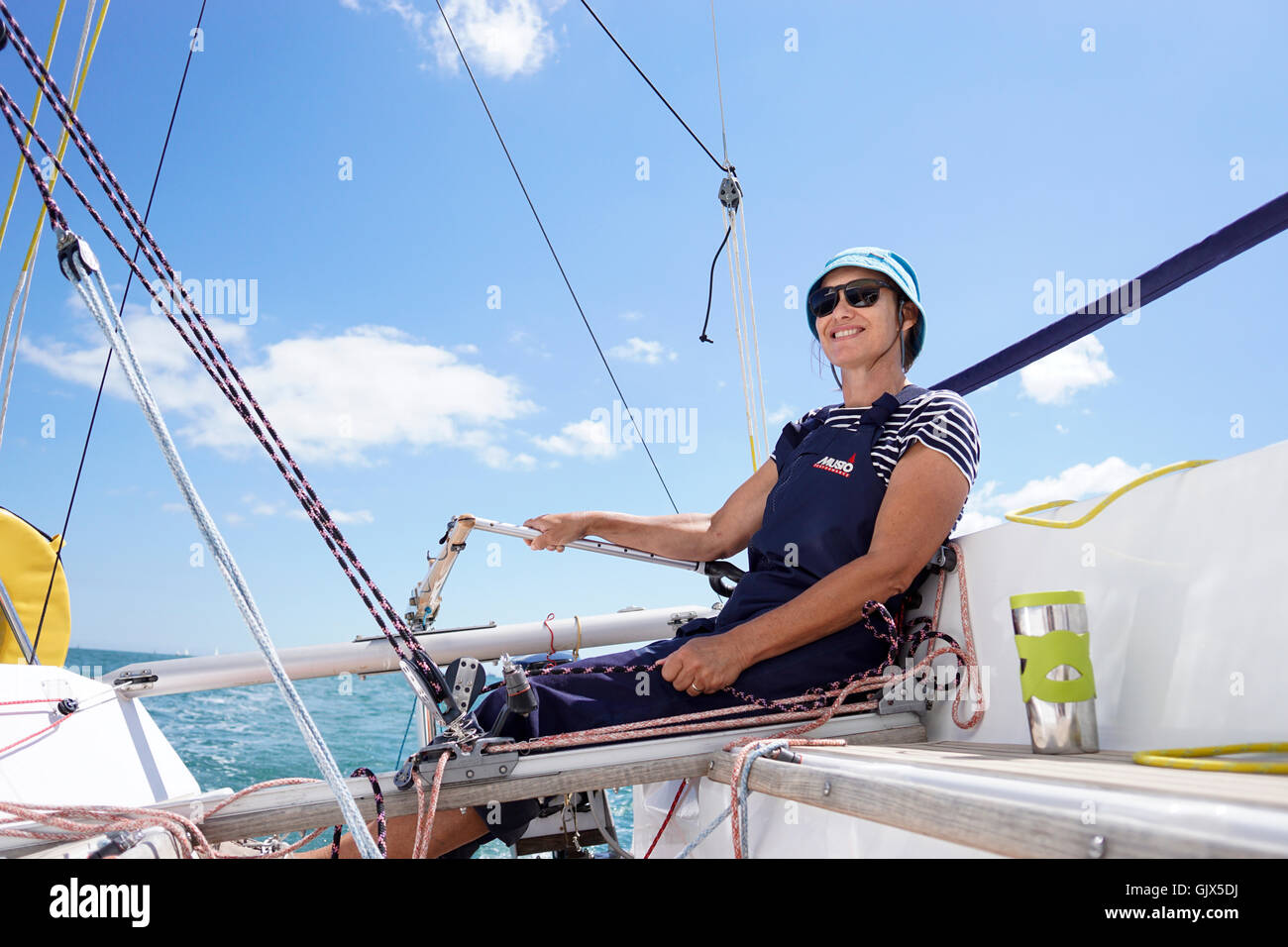 Woman helming sailing boat Stock Photo