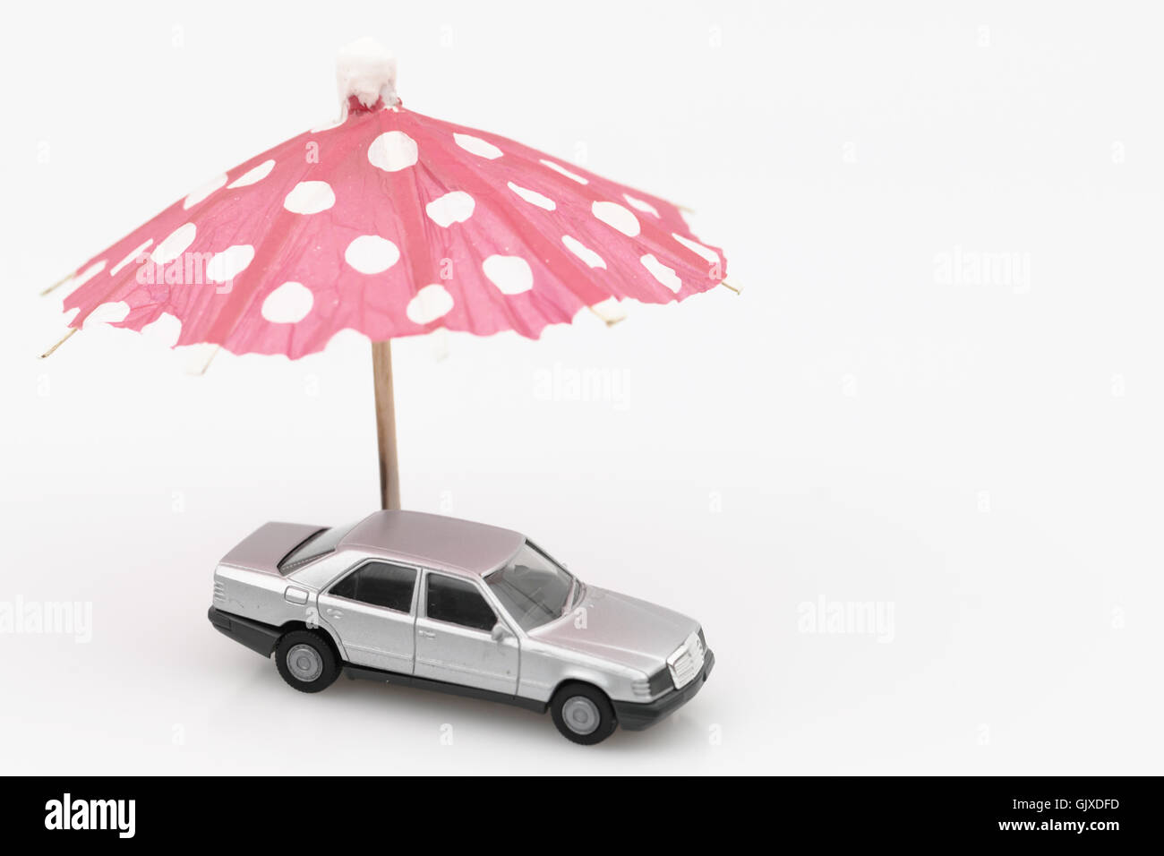 Gray car under red umbrella, isolated on white Stock Photo