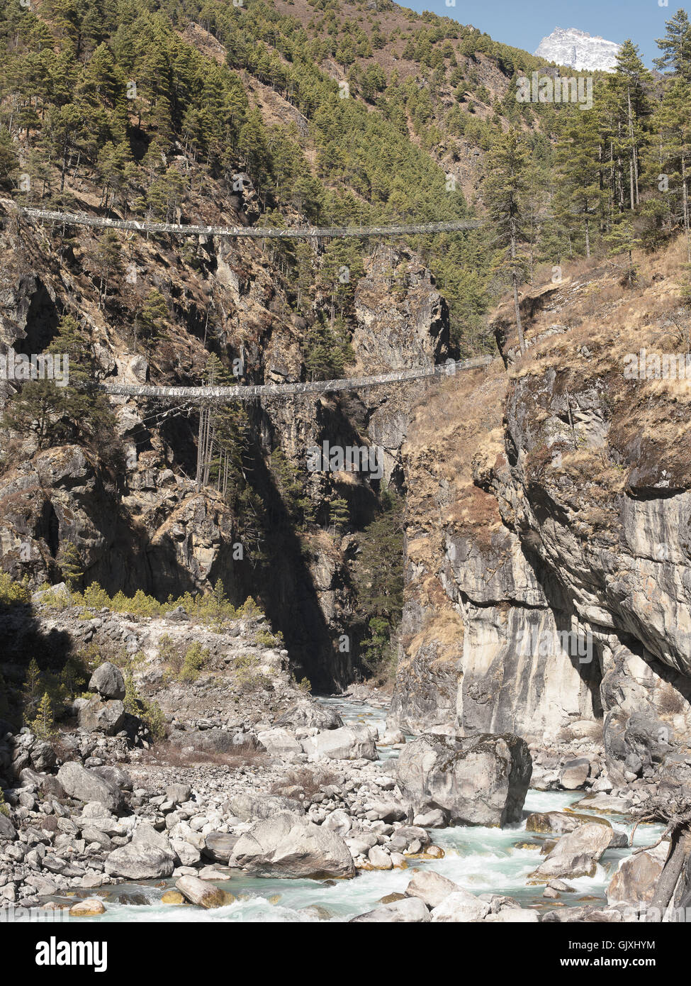 Suspended bridges over a rushing river through Nepal's Everest Base Camp Stock Photo