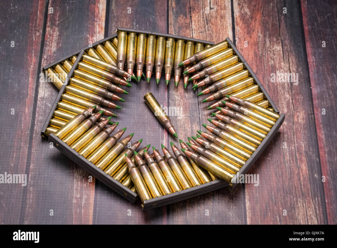 Ammunition, .223/556, arrange in a pattern the shape of the Pentagon on dark wood surface. Stock Photo
