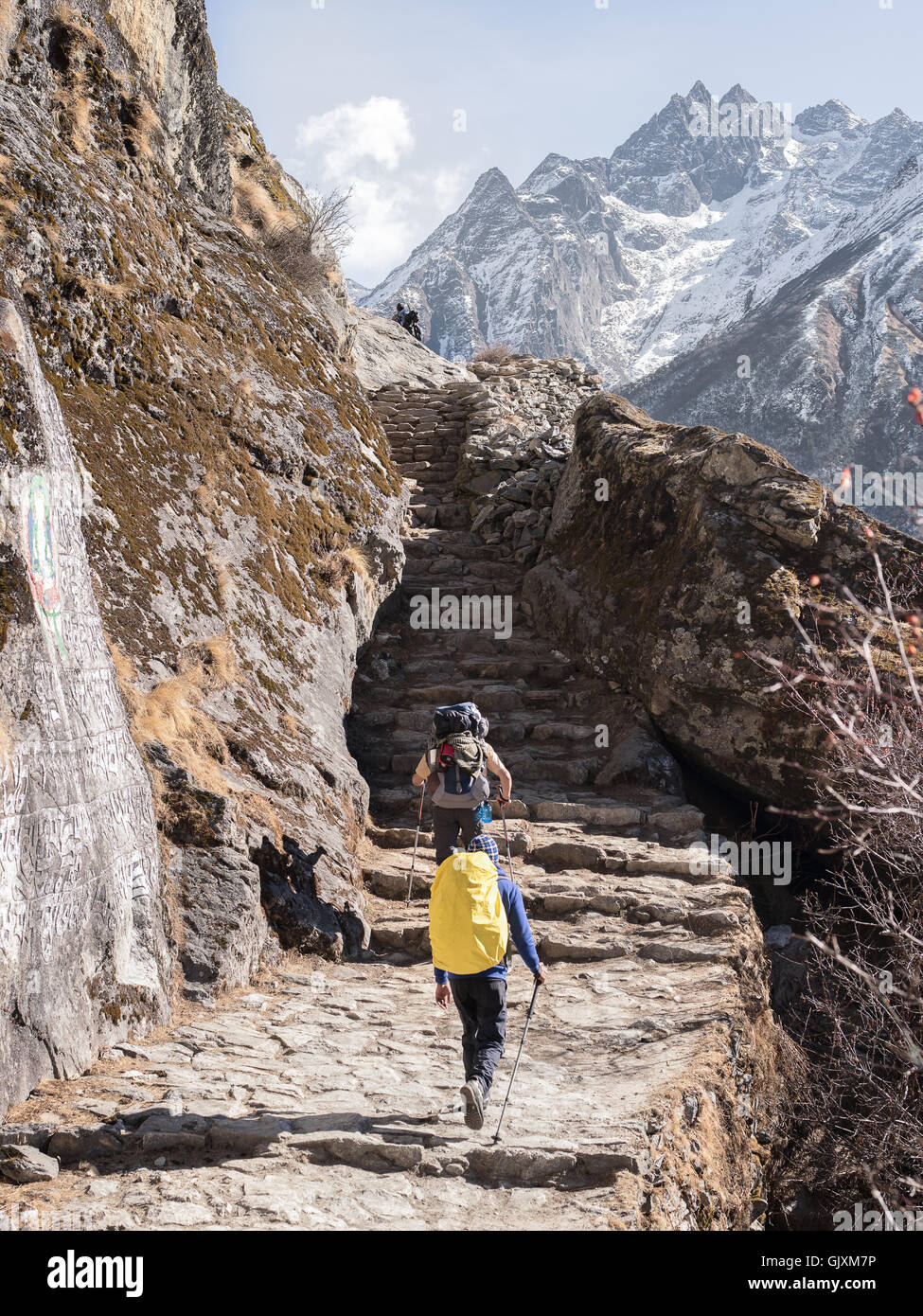 Backpackers make their way up steps as they journey through Nepal's Everest Base Camp in the middle of winter Stock Photo