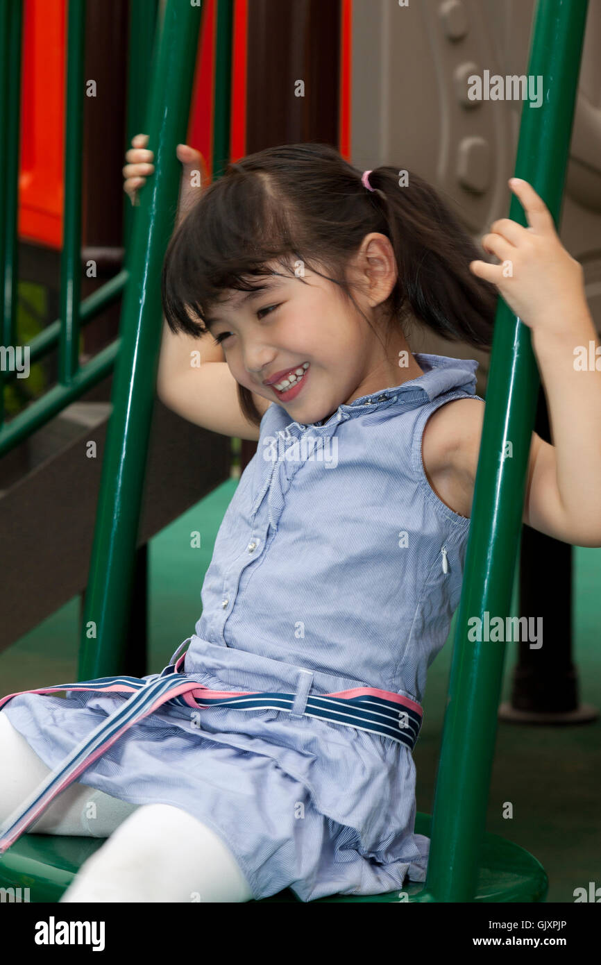 Little girl playing in kindergarten slides Stock Photo Alamy