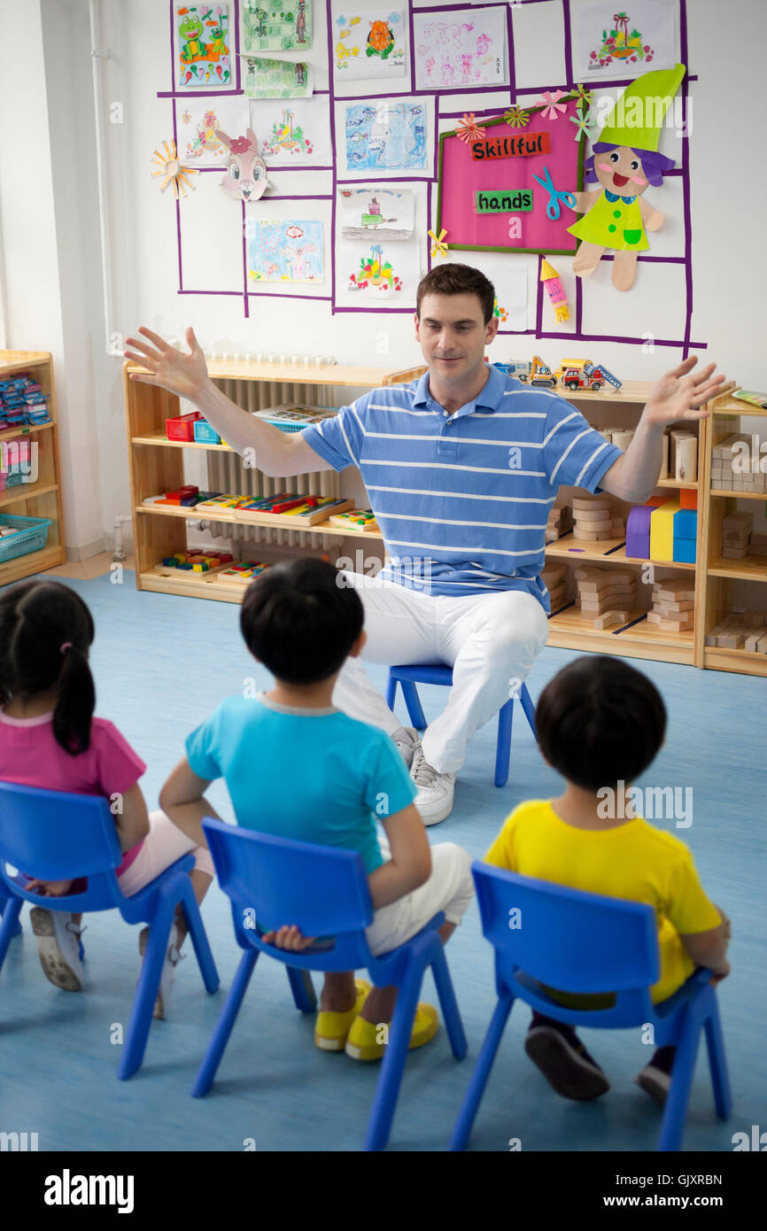 Teacher and children playing together Stock Photo
