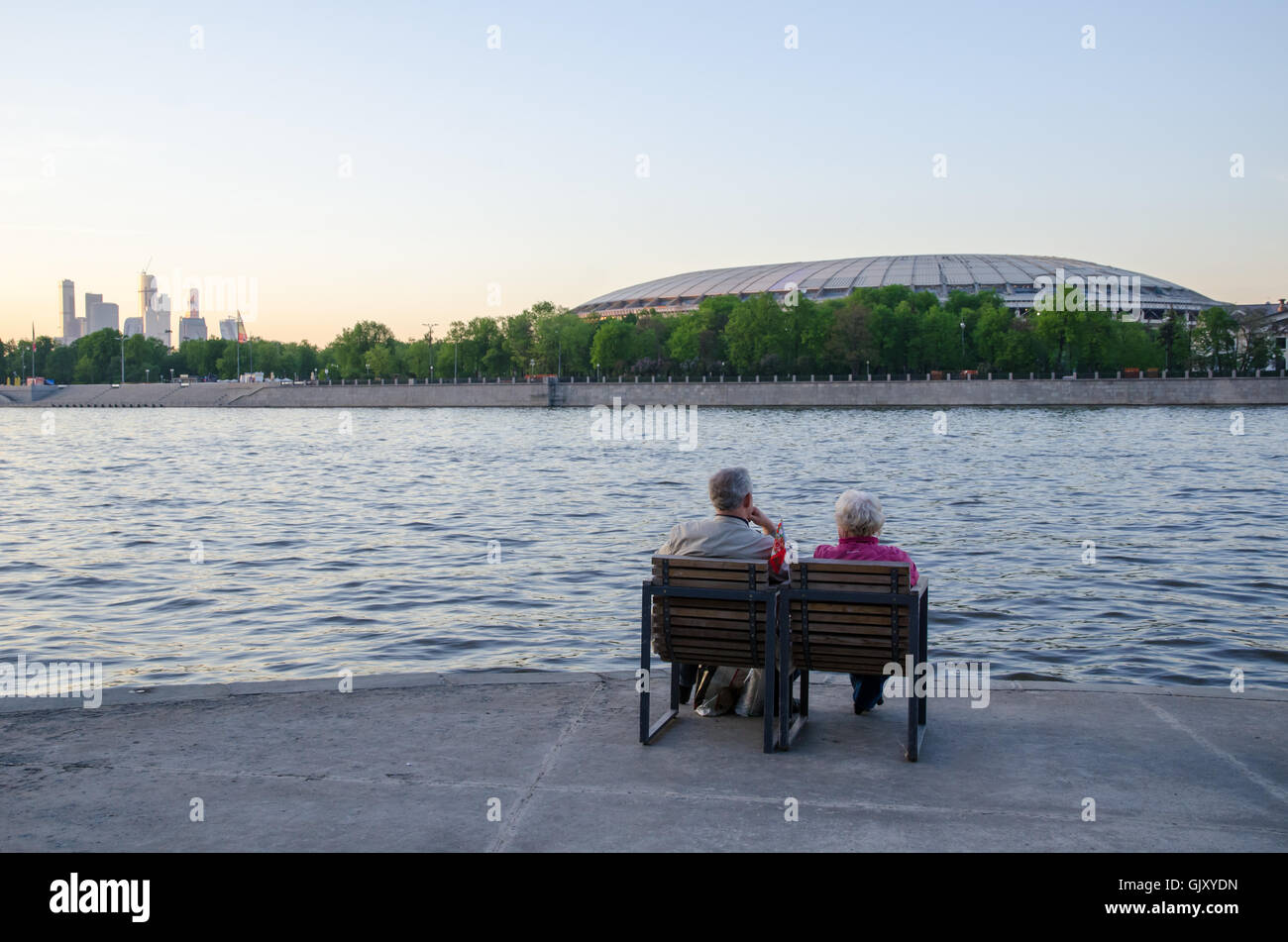 Two elderly people sitting on the bank of the river in chairs Stock Photo
