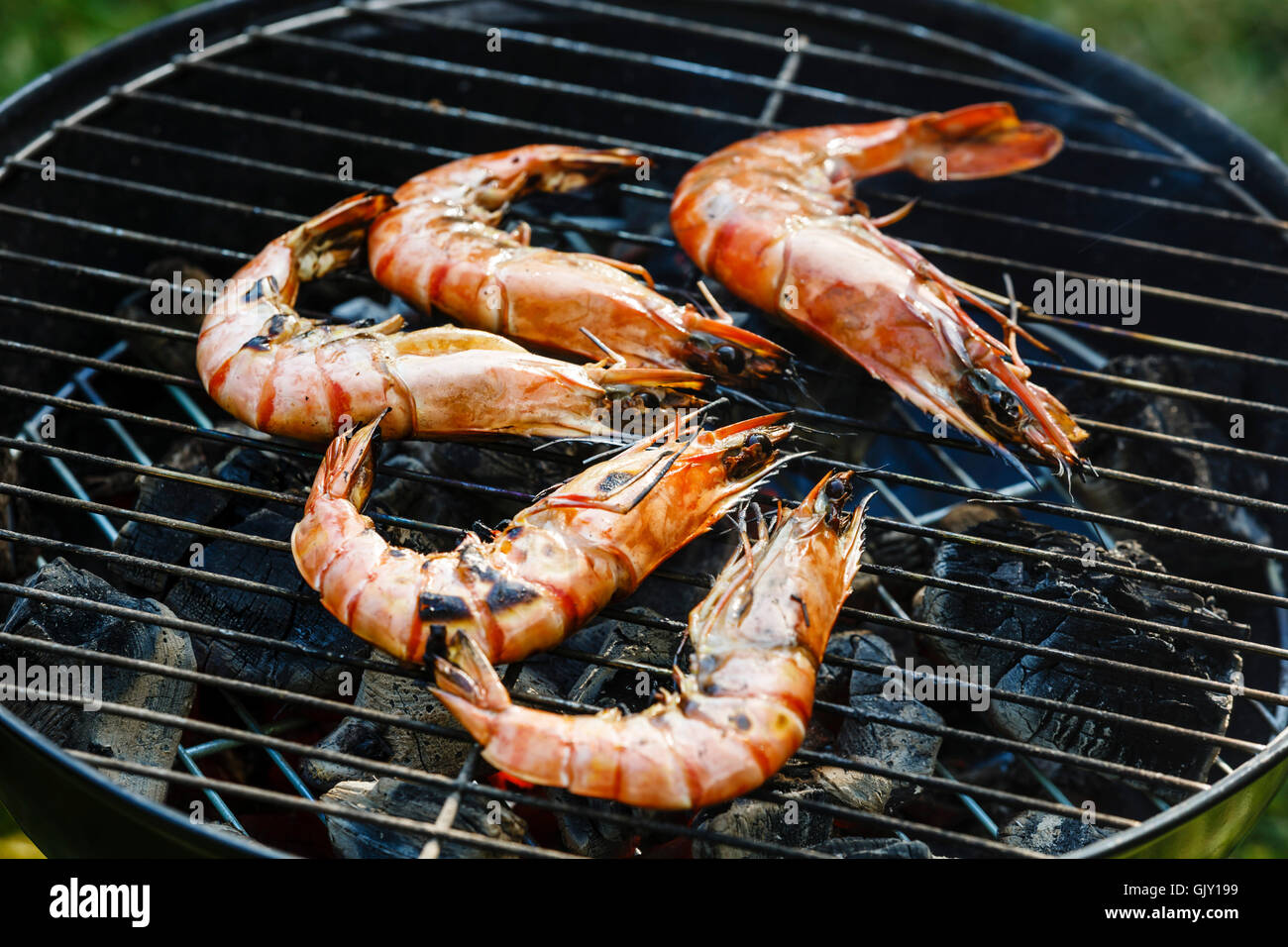 Grilled king size Prawns on grill BBQ background Stock Photo
