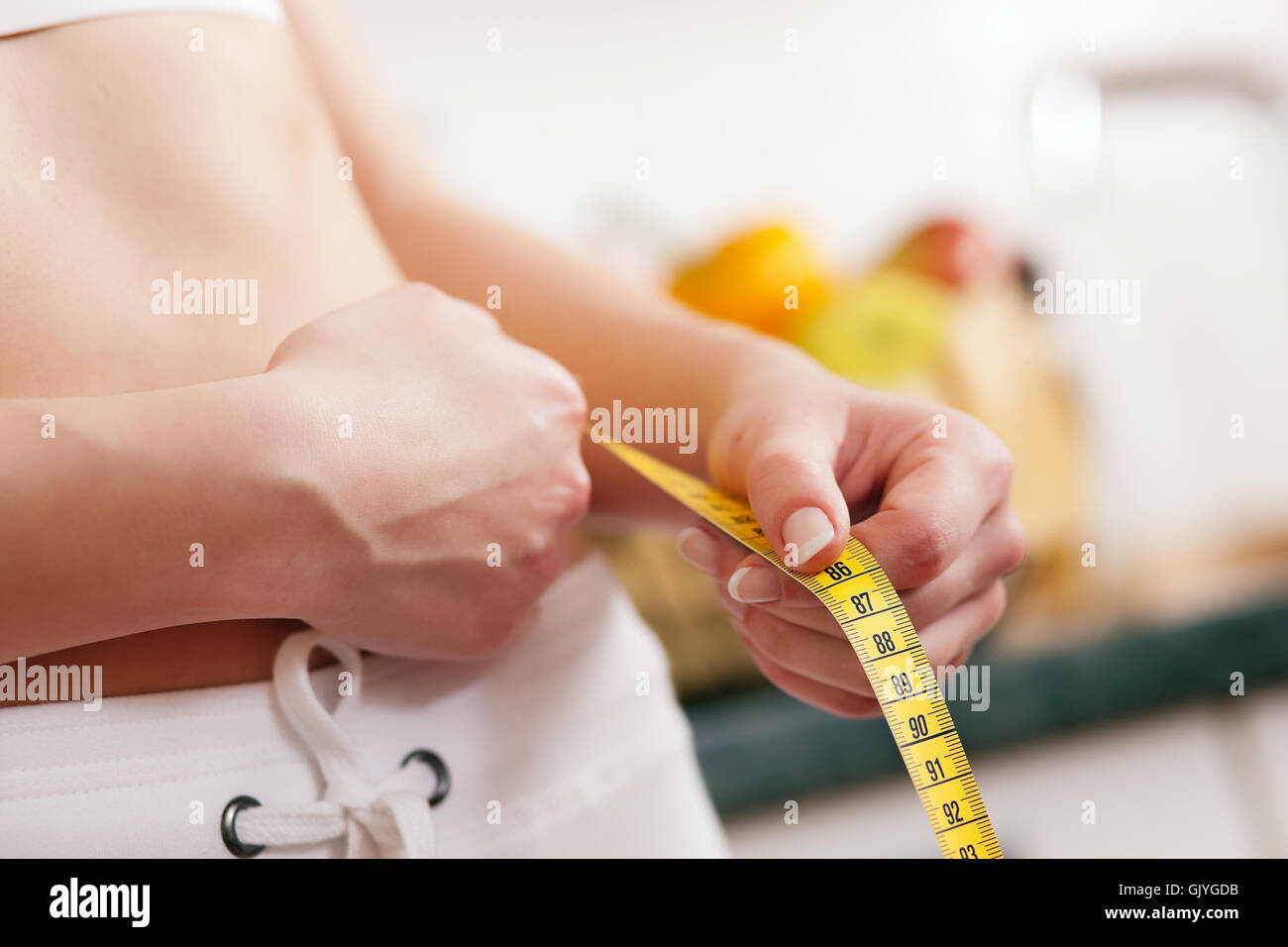 woman measures waist with tape measure Stock Photo Alamy