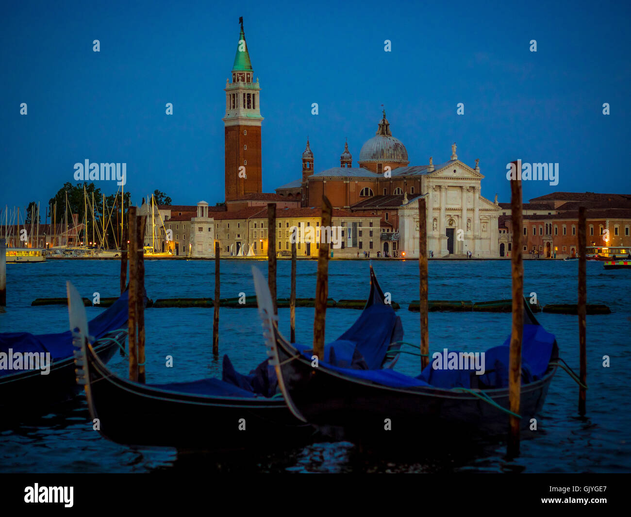 Gondolas moored in St Mark's Basin with  in the background, at night. Venice, Italy. Stock Photo