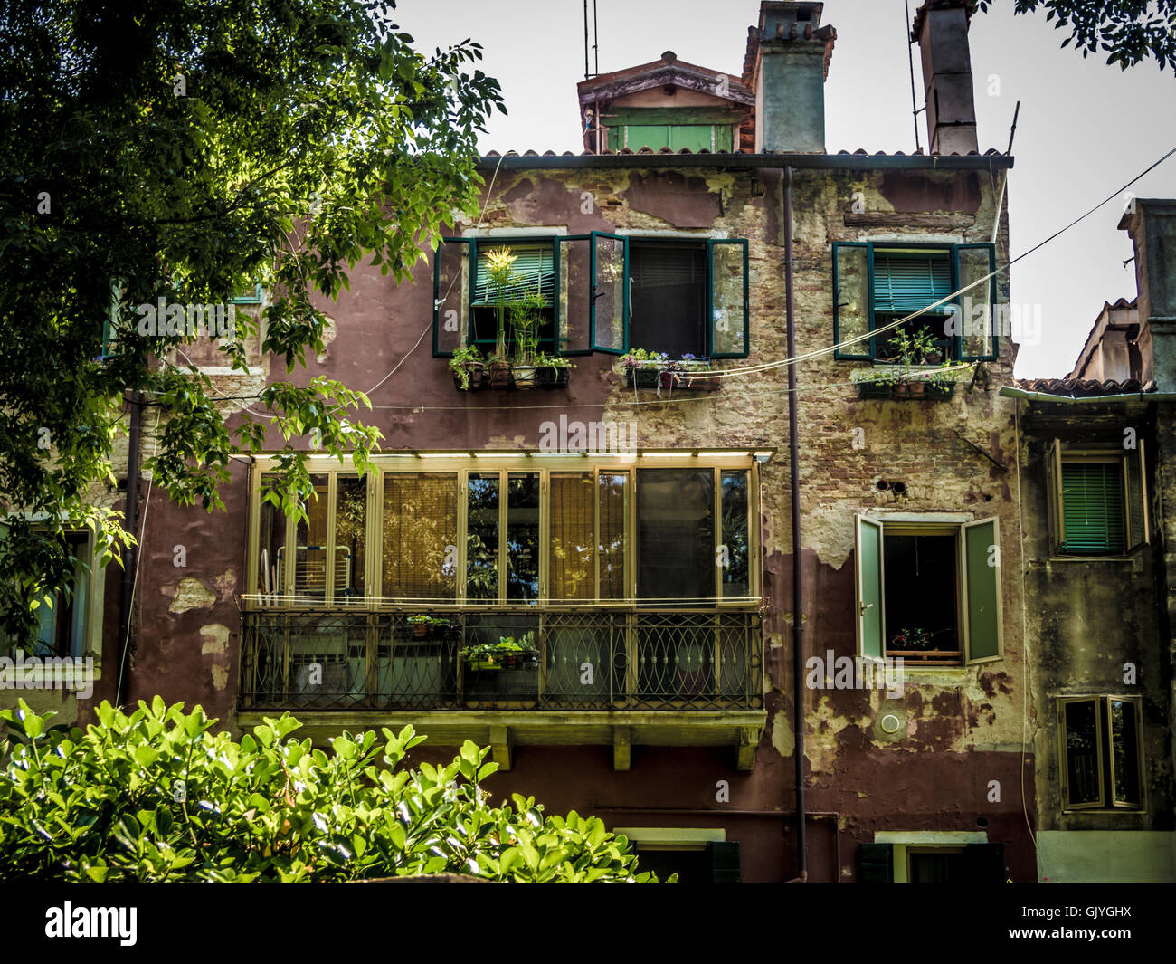 traditional brown rendered building with Venetian blinds and shutters at the windows. Stock Photo