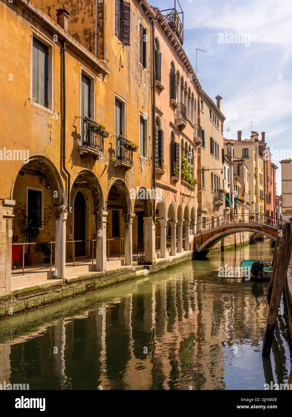 Narrow canal or rio with arched foot bridge alongside traditional buildings. Venice, Italy. Stock Photo