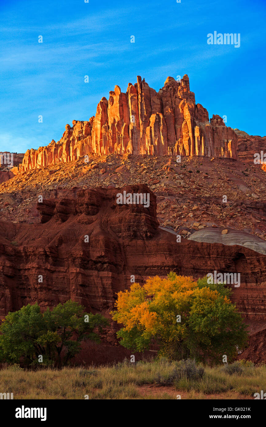 In this vertical shot the late-afternoon sun lights up 'The Castle' formation in Capitol Reef National Park Utah Stock Photo