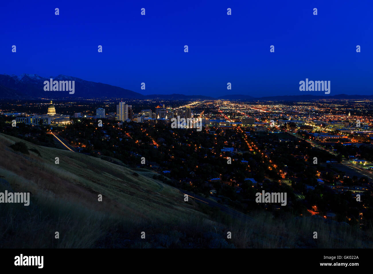 This is a evening view of the Salt Lake Valley and buildings of downtown Salt Lake City as the evening lights come on. Stock Photo
