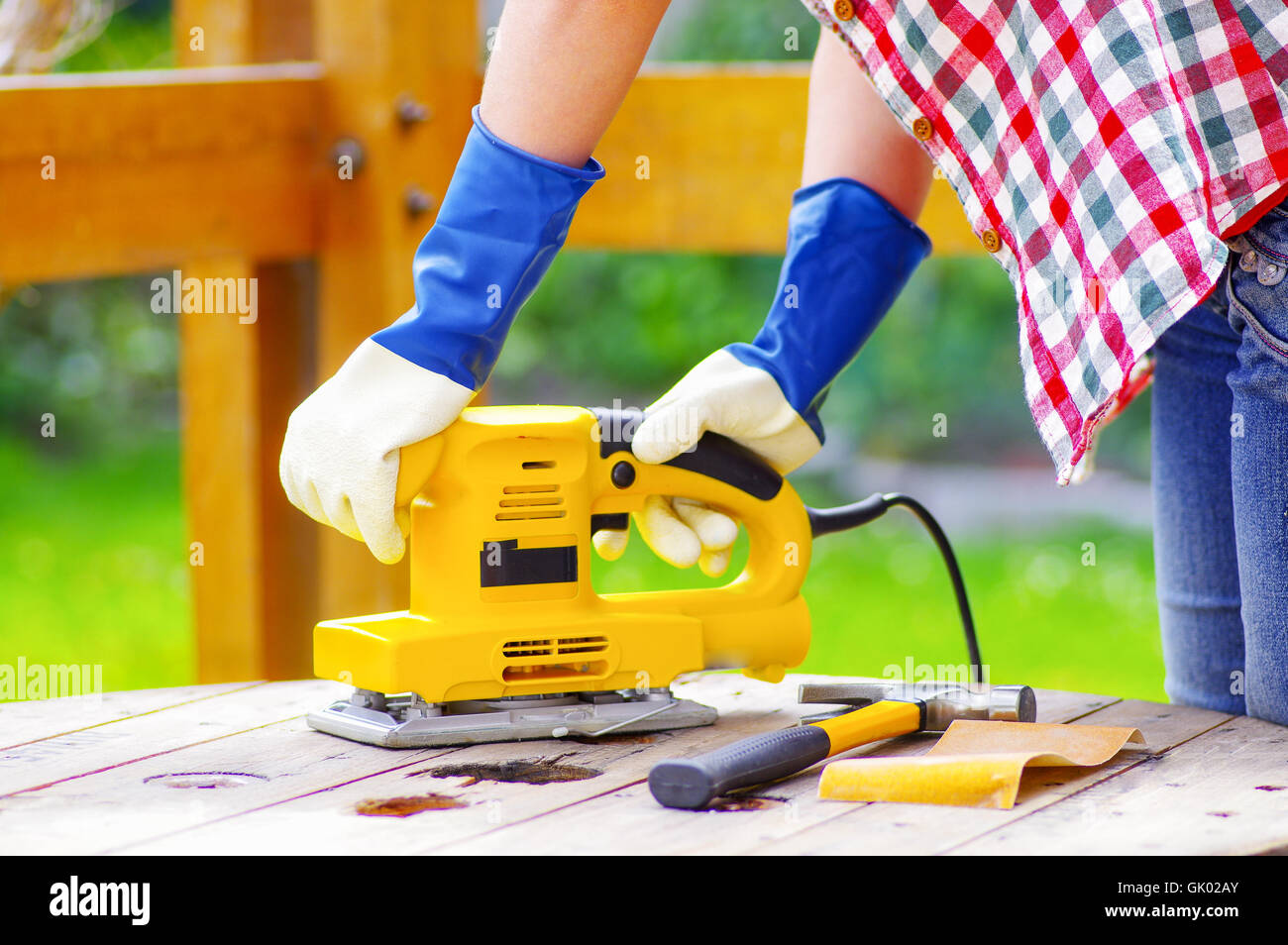 hands holding a eletric sander while sanding a table Stock Photo Alamy